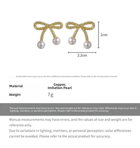 Detailed view of pearl bow earrings in gold finish with 2.2cm x 2cm size specifications