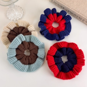 Set of four contrast knit hair scrunchies in deep brown, blue and red on white background