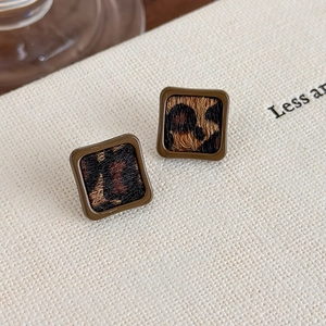 Détail de boucles d'oreilles carrées vintage avec motif léopard et monture marron foncé