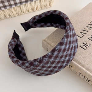 Detail of vintage plaid padded headband with soft brown and blue checkered fabric texture