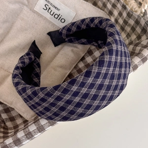 Detail of navy plaid thick padded headband on beige canvas bag with textured fabric finish