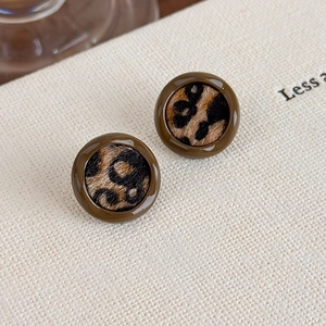 Vue macro détaillée de boucles d'oreilles léopard avec bords en résine vintage