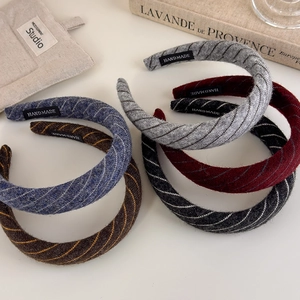 Detailed close-up of handmade striped knitted headbands in multiple elegant colors
