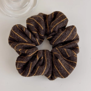 Detailed view of autumn winter striped knitted scrunchie with warm wool texture