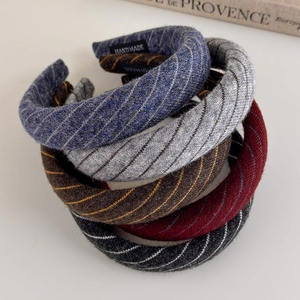 Close-up of padded striped knit headbands featuring the black handmade woven label tag
