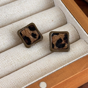 Vue détaillée de boucles d'oreilles carrées motif léopard avec bordure marron foncé