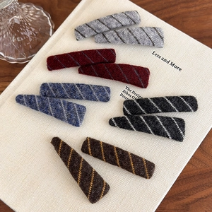 Plush diagonal striped hair clip set in five retro colors on fabric texture background