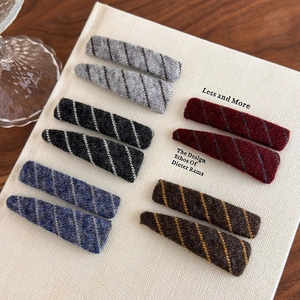 Detail shot of plush diagonal striped hair clips in various autumn colors and shapes