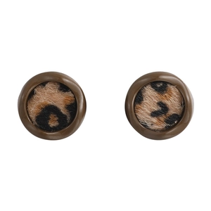Gros plan sur des boucles d'oreilles rondes léopard avec texture peluche et bord brun