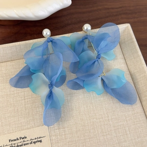 Detail of blue organza flower petal earrings with white pearls in a jewelry tray