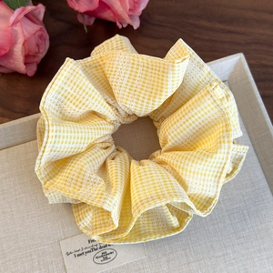 Gros plan du chouchou vichy jaune avec broderie dentelle et bords ondulés