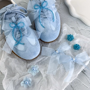 Nœud en résille bleue et breloques en perles sur baskets en daim bleu pour femme