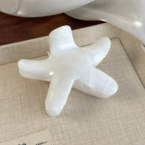 Macro shot of large starfish hair claw clip with elegant white marble texture finish