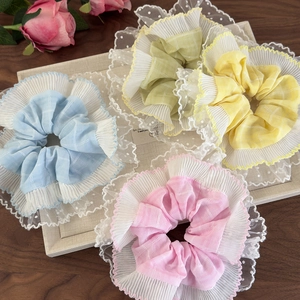 Détail de quatre chouchous en tulle pastel avec bordure en dentelle et pois blancs