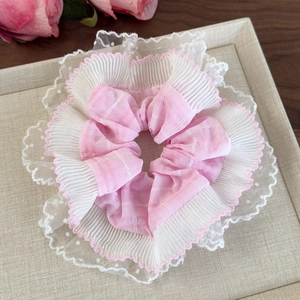 Détail du chouchou à carreaux roses avec bordure en dentelle blanche et maille à pois