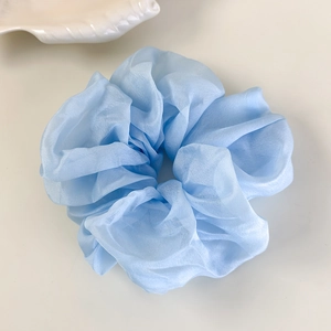 Gros plan du chouchou à carreaux bleu clair avec texture en organza doux et dentelle