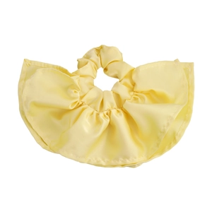 Détail d'un chouchou à carreaux jaune doux avec texture plissée satinée et brillante