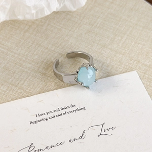 Detailed view of silver starfish ring with light blue stone on romantic paper background