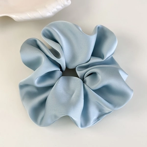 Gros plan détaillé d'un chouchou en satin bleu clair avec texture soyeuse et éclat chic