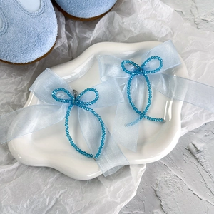Vue détaillée du nœud en organza bleu clair avec perles de cristal pour accessoires de chaussures