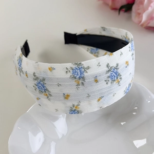 Vue détaillée d'un serre-tête floral avec roses bleues sur une assiette décorative