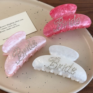 Three large marble texture hair claws with rhinestone Bride lettering in pink and cream