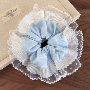 Détail du motif à carreaux bleu clair et de la dentelle blanche sur ce grand chouchou