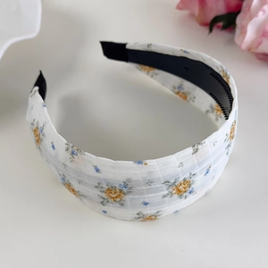 Détail des dents antidérapantes internes et du motif floral du serre-tête en tissu
