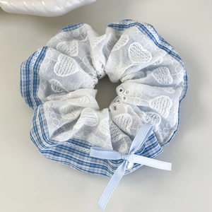 Détail du chouchou à carreaux bleus avec dentelle blanche, broderie cœur et nœud en perle