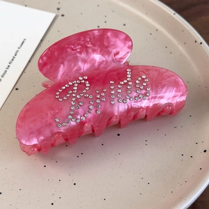 Pink marble acetate hair claw clip with Bride rhinestone lettering on ceramic tray