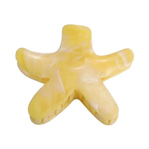 Detail view of yellow marble starfish hair claw clip with glossy acetate texture