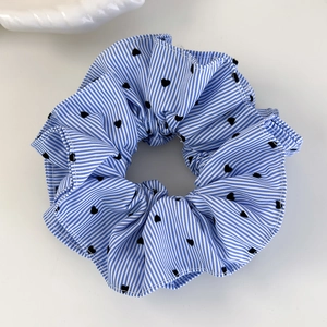 Gros plan du chouchou à rayures bleues et blanches avec motifs cœurs et dentelle