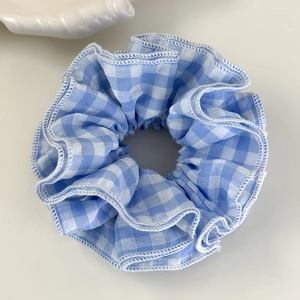 Vue détaillée du chouchou à carreaux bleu et blanc avec finition à bord roulé fin