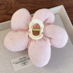 Détail de la pince à cheveux fleur rose à cinq pétales tricotée avec ressort doré