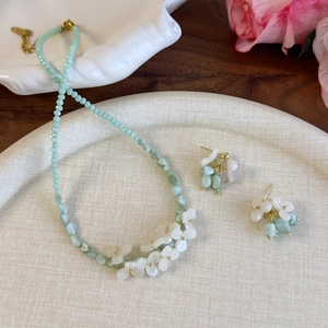 Ensemble de bijoux en perles vert menthe avec collier et boucles d'oreilles sur assiette