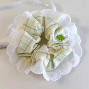 Détail du chouchou à carreaux jaunes avec dentelle brodée et étiquette Hand Made