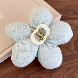 Détail de la pince à cheveux fleur en tissu vert menthe avec texture côtelée et clip ivoire
