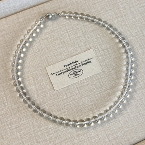 Detail shot of grey transparent acrylic bead necklace with a silver magnetic ball clasp