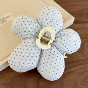 Détail de la pince à cheveux fleur à pois bleus avec texture en coton brodé élégante