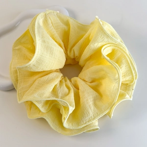 Gros plan détaillé d'un chouchou jaune à fleurs avec texture en tissu seersucker gaufré