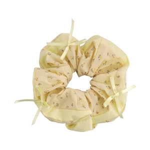 Coletero con estampado floral amarillo suave con detalles de lazos y borde de satén
