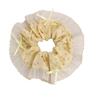 Detalle de coletero floral amarillo con bordes plisados de gasa y lazos de cinta de seda
