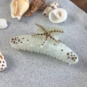 Détail d'une pince à cheveux étoile de mer avec strass et décorations de coquillages