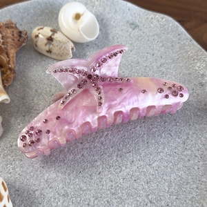Détail d'une pince à cheveux motif marbre rose avec étoile de mer ornée de cristaux