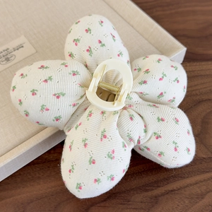 Vue détaillée de la pince à cheveux en tissu floral avec motifs roses et ressort doré