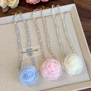 Detailed view of handmade beaded choker necklaces with oversized mesh rose pendants