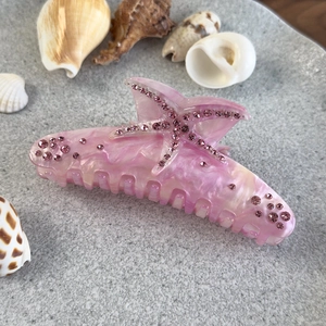 Détail de la pince à cheveux étoile de mer rose avec texture marbrée et strass brillants