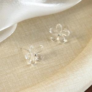 Vue macro de boucles d'oreilles fleurs en résine transparente avec coeur argenté