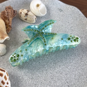 Vue détaillée de la pince à cheveux étoile de mer marbrée avec strass verts