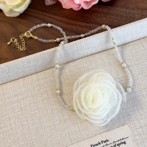 Detail of French vintage necklace with large white fabric rose and pearl beads